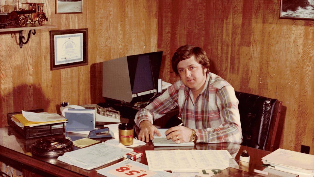 Bob Barks takes care of some paperwork in his office in this early, undated photo. Sharp-eyed readers will notice the microfiche reader behind him and to the right.