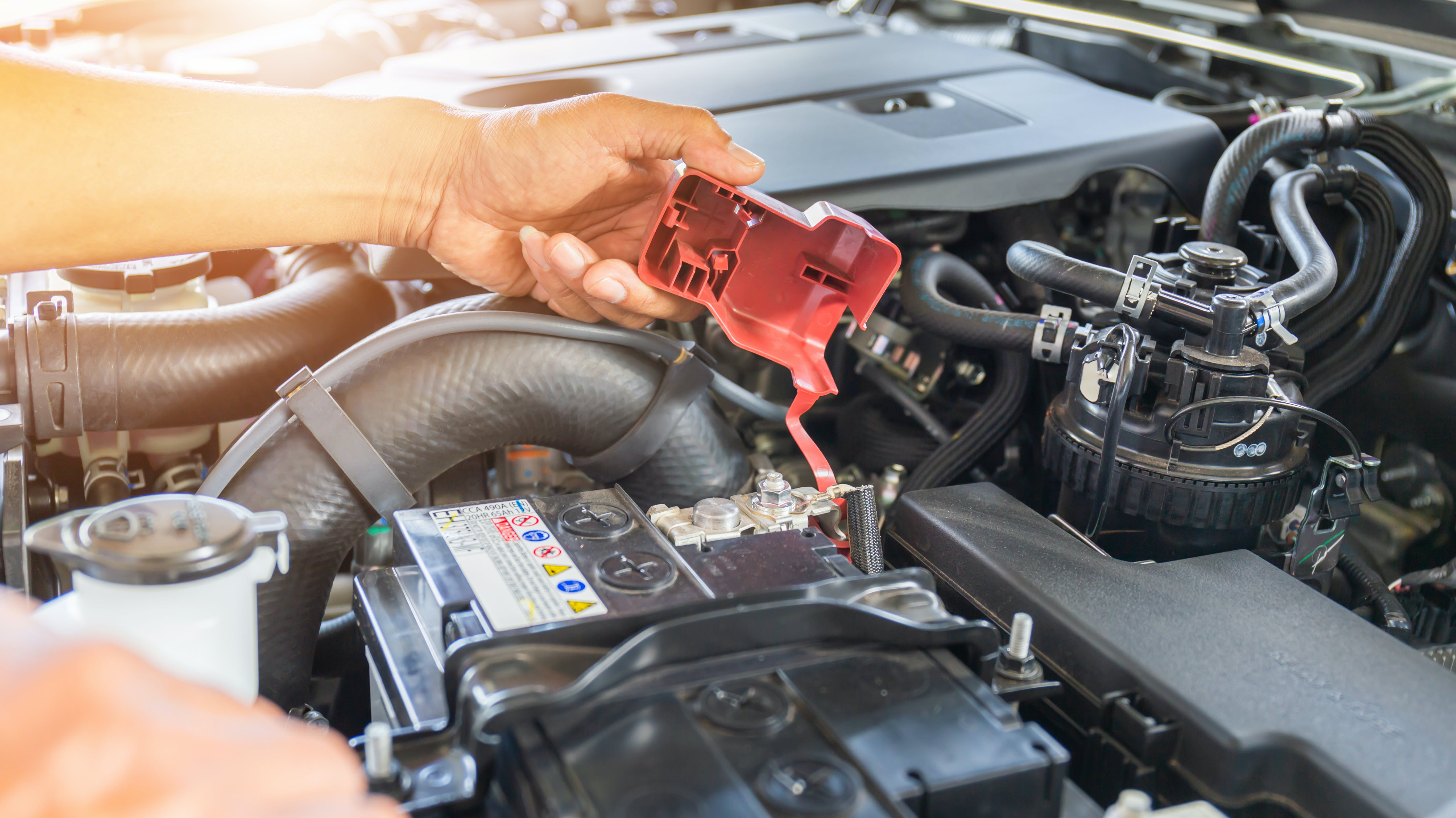 Technician removing battery terminal cover