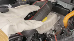 A technician wearing proper PPE tests underhood components.