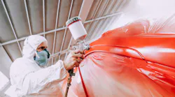 Painter with red car in booth