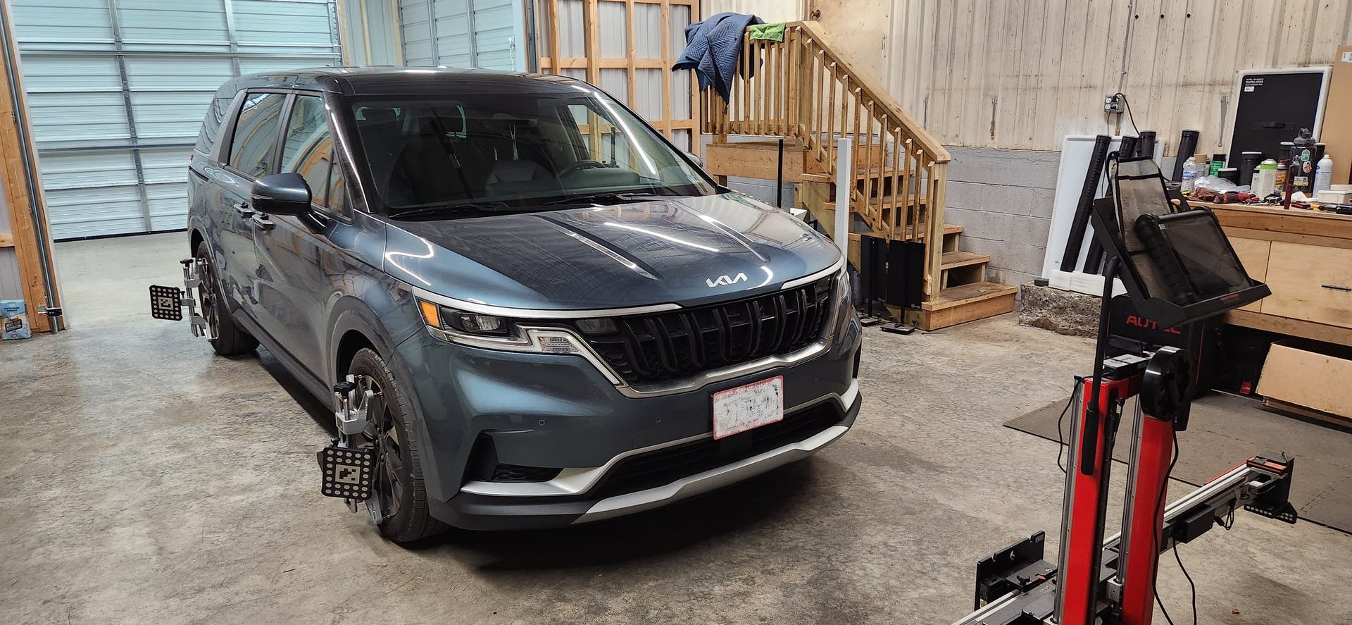 SOS Repair's ADAS bay with the Autel IA800 ADAS Optical Positioning System and ADAS software-equipped MaxiSYS tablet, ready to calibrate a Kia Carnival.