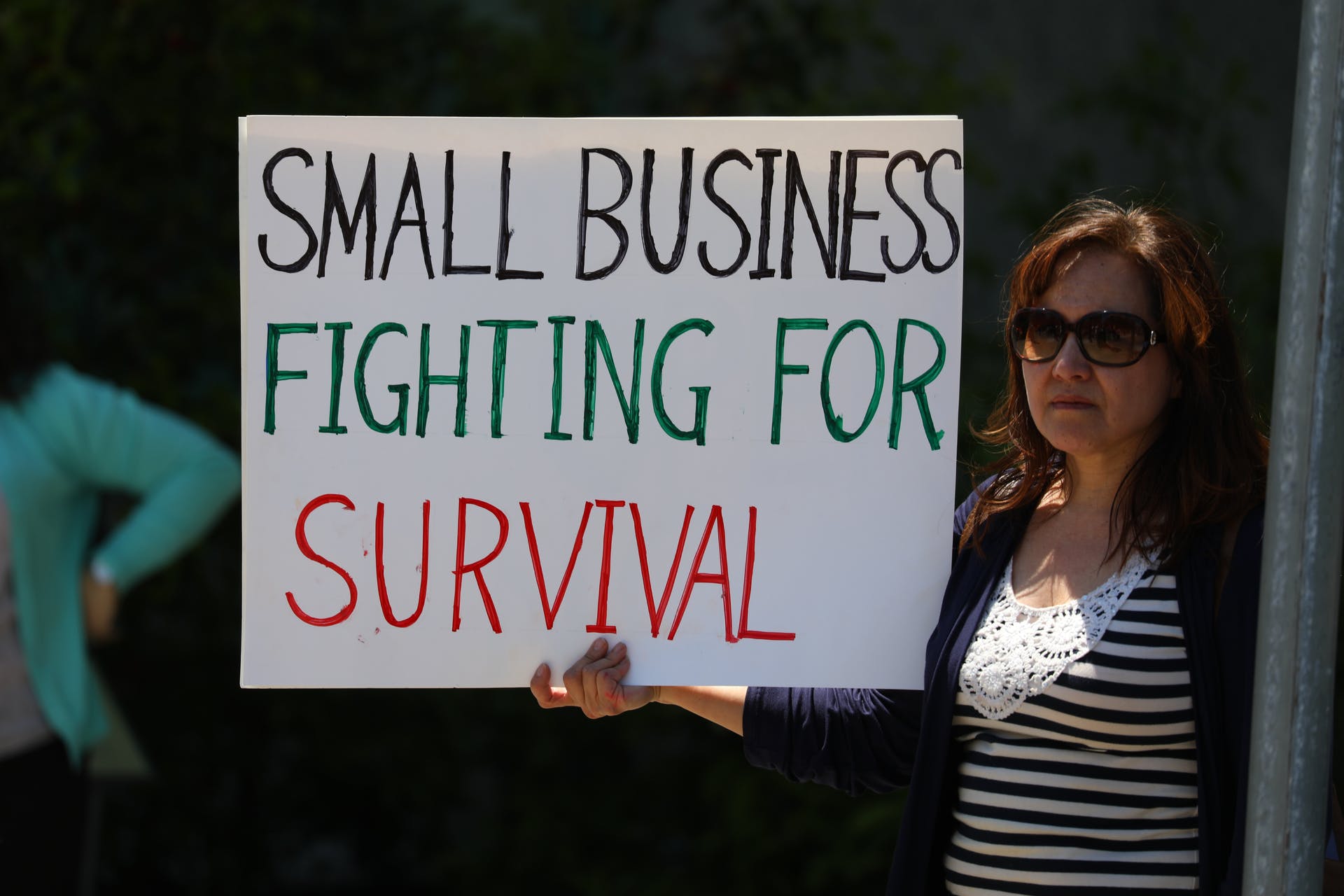 A woman holds up a sign at ReOpen NC rally in Raleigh, North Carolina.