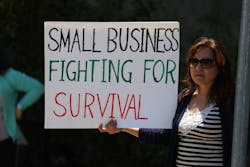 A woman holds up a sign at ReOpen NC rally in Raleigh, North Carolina. A woman holds up a sign at ReOpen NC rally in Raleigh, North Carolina.