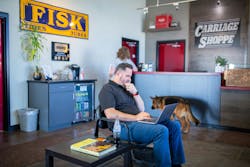 Ryan Green, marketing director for Yoder Family of Companies, using laptop in Carriage Shoppe lobby. Ryan Green, marketing director for Yoder Family of Companies, using laptop in Carriage Shoppe lobby.