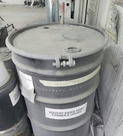 This drum of liquid solvent waste is properly labeled and grounded, as shown by the red clamp at the rear. This drum of liquid solvent waste is properly labeled and grounded, as shown by the red clamp at the rear.