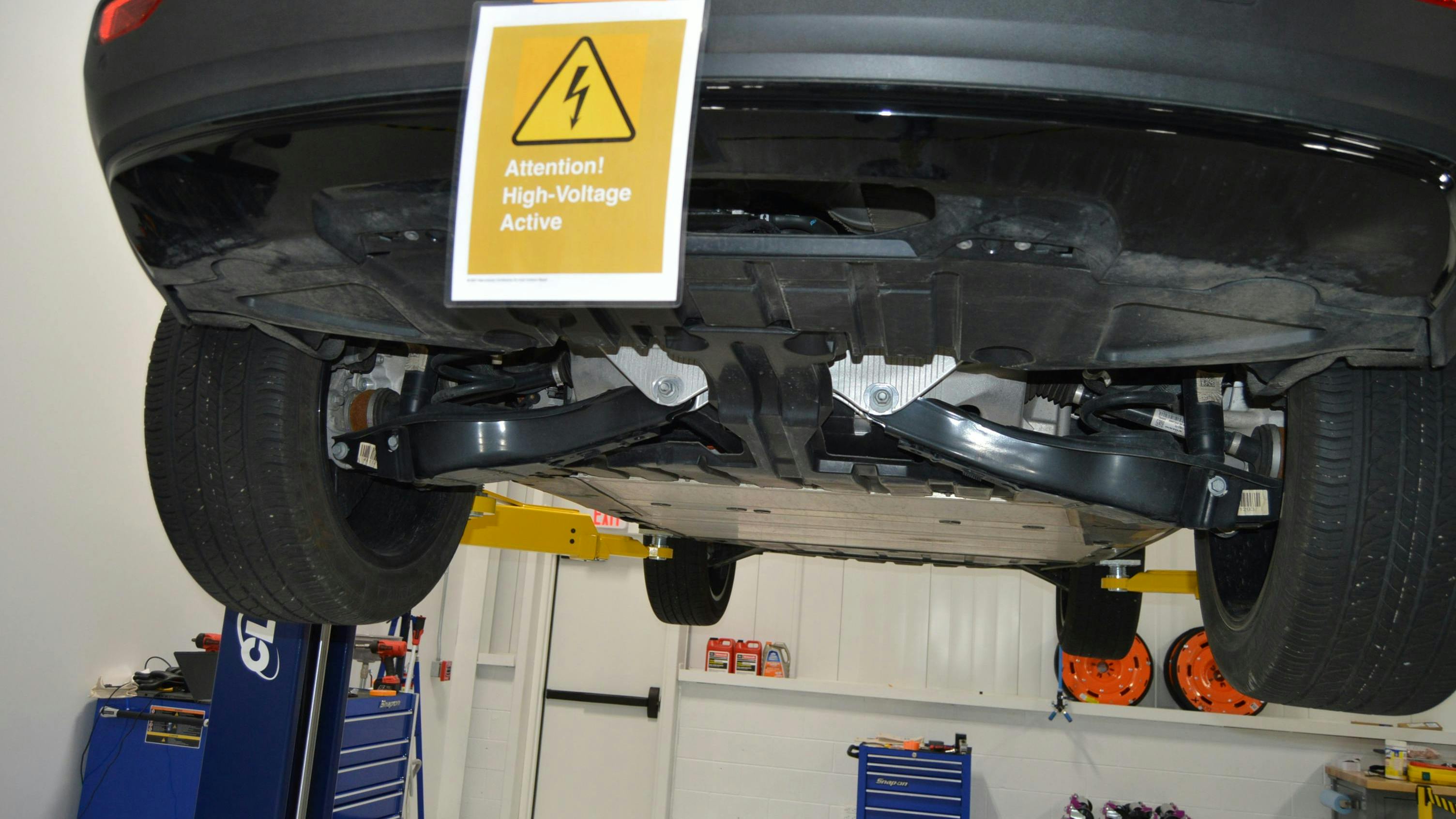 As this placard at I-CAR's Chicago Technical Center shows, it's critical to use a placard for EVs that have not had their battery disabled. A lift table is needed for this type of two-post lift to handle the battery.