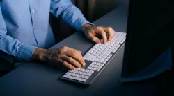 man_in_buttonup_blue_shirt_at_keyboard_dreamstime_