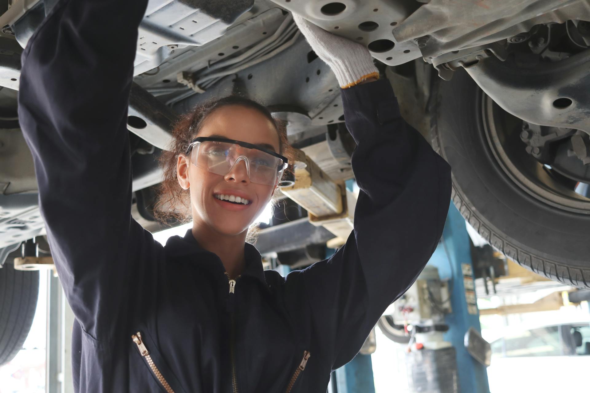 Young woman working under car