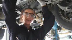 Young woman working under car