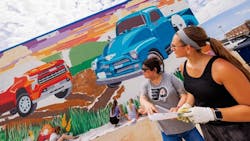 Sandra Williams, center, and Maddie Vanderbur, a senior in graphic design and the mural&rsquo;s designer, look over a printout of the mural.