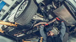 Technician examining exhaust system
