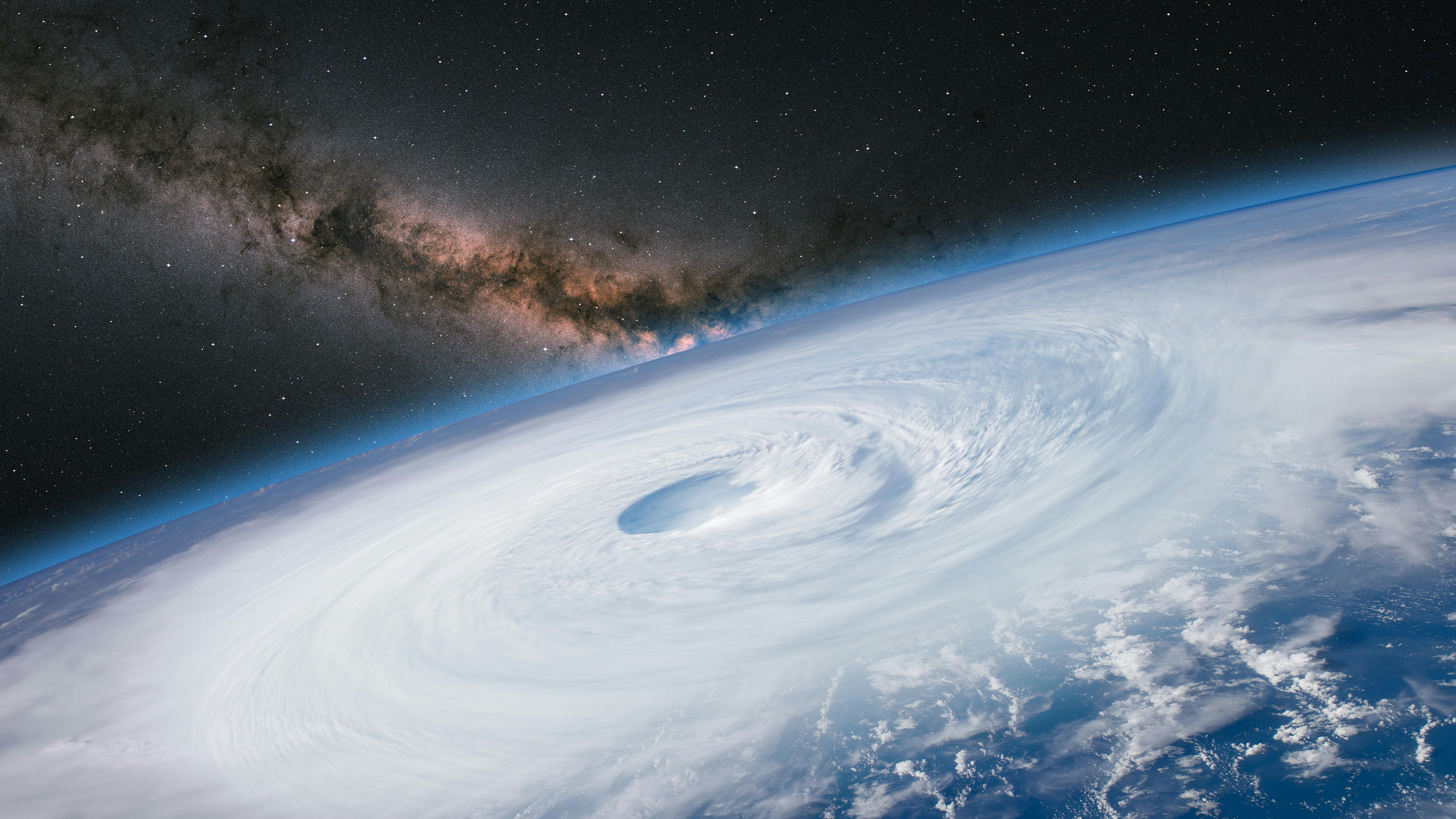 This stock image of a hurricane viewed from a NASA satellite shows the Milky Way galaxy at sunset.