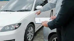 Adjuster inspecting car