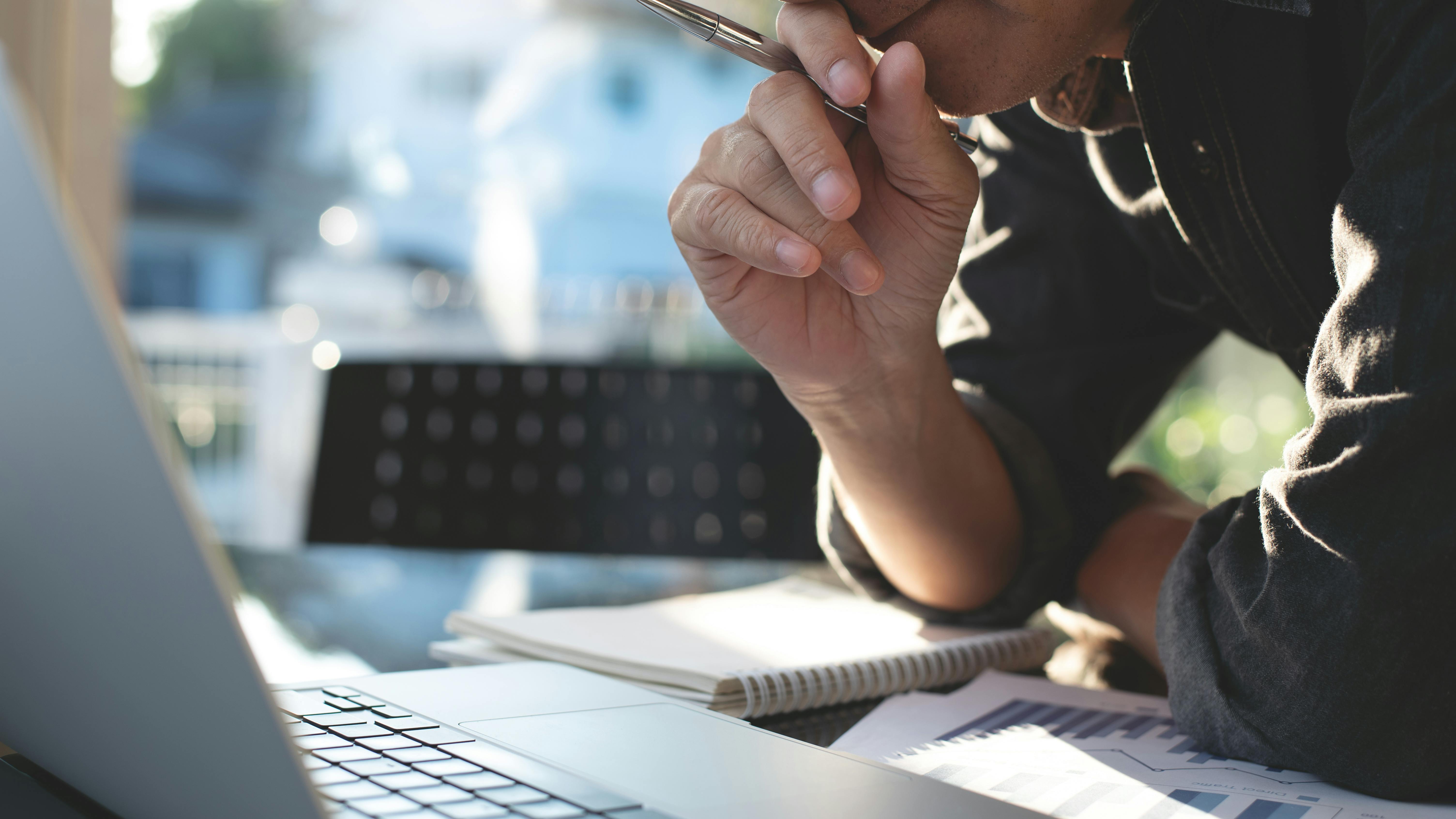 Man pondering computer screen