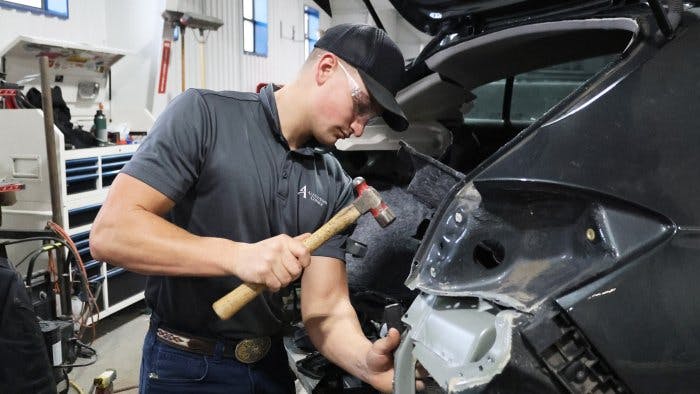 Landon Spoonhower works on one of the cars that is part of the Wreck Rebuild program.