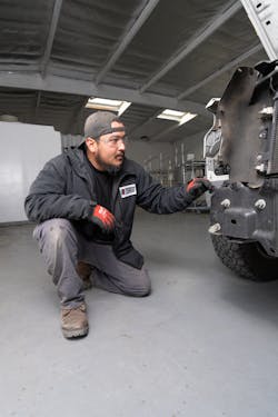 tech_kneeling_inspecting_front_of_car tech_kneeling_inspecting_front_of_car