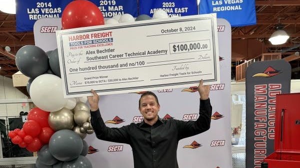 Alex Bechtler, a manufacturing teacher at Southeast Career Technical Academy in Las Vegas, celebrates with his $100,000 check as a 2024 Harbor Freight Tools for Schools Grand Prize winner.