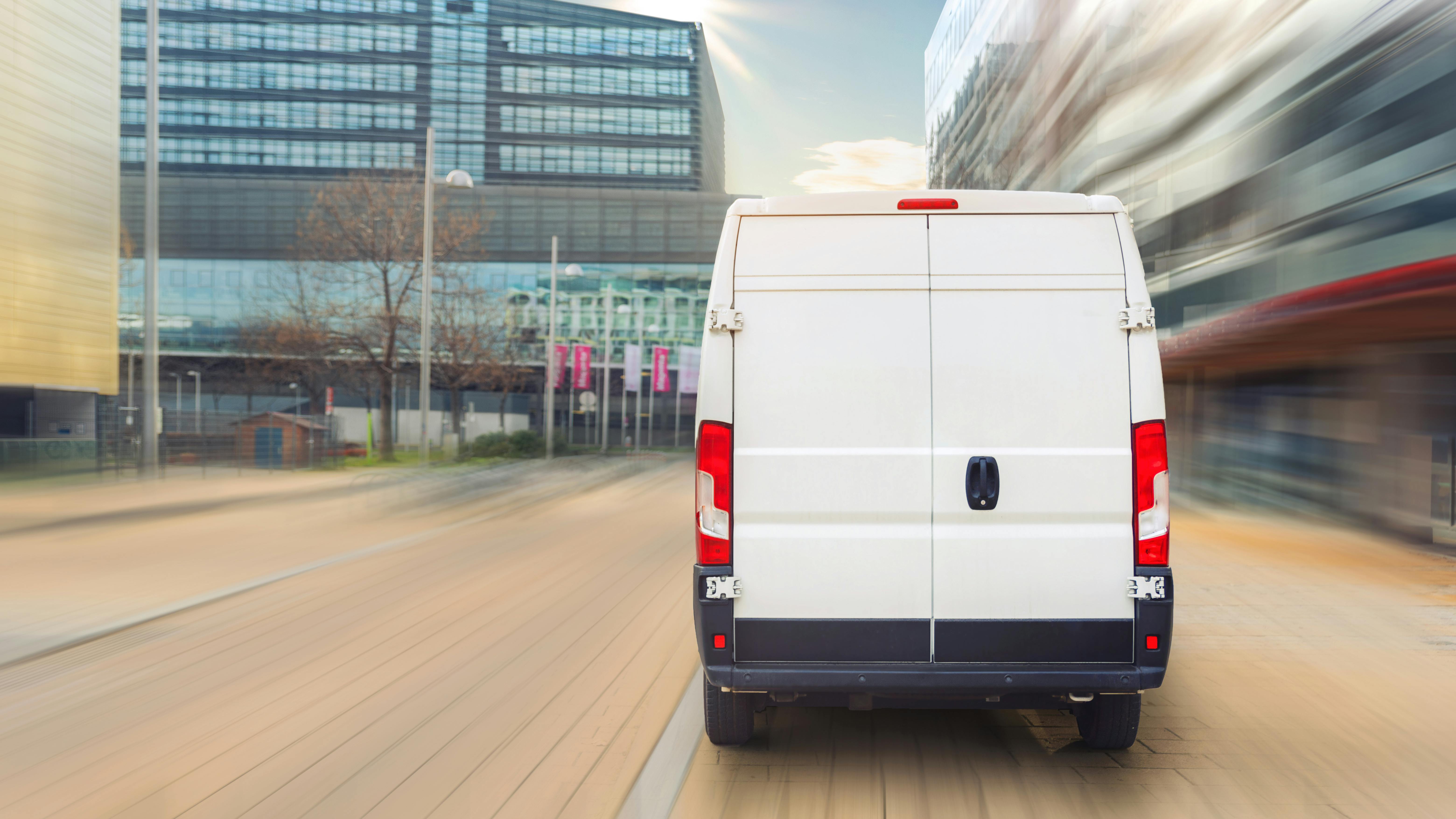 White delivery van in motion on the street