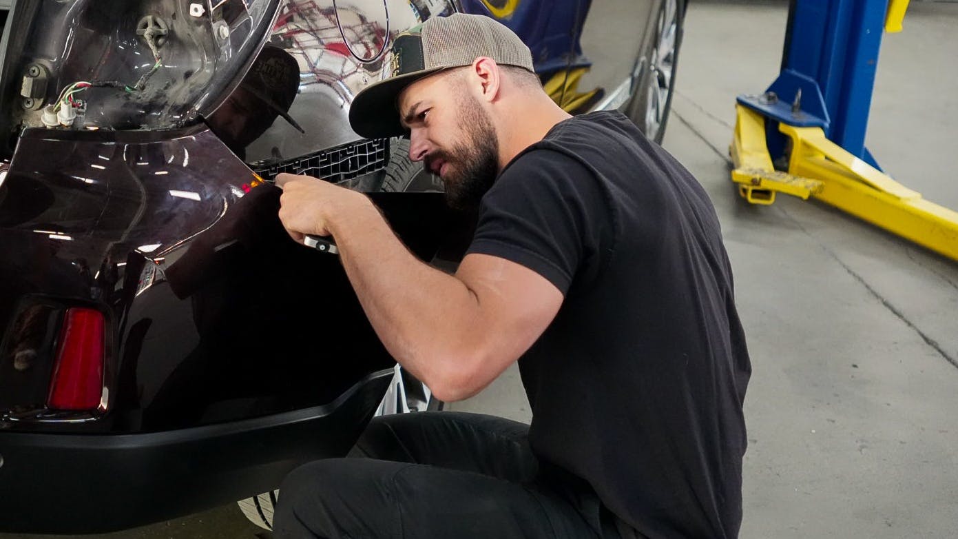 LEAD BY EXAMPLE: Showtime Collision Operator and Shop Manager Tyler Makeig assists with a fitment concern on a Subaru Outback. His hands-on leadership style is the foundation of the shop's culture.