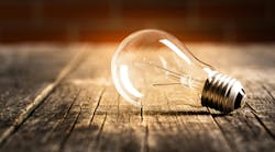 Incandescent lightbulb on old wooden planks Incandescent lightbulb on old wooden planks