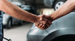 Shop owner and customer shaking hands in shop Shop owner and customer shaking hands in shop
