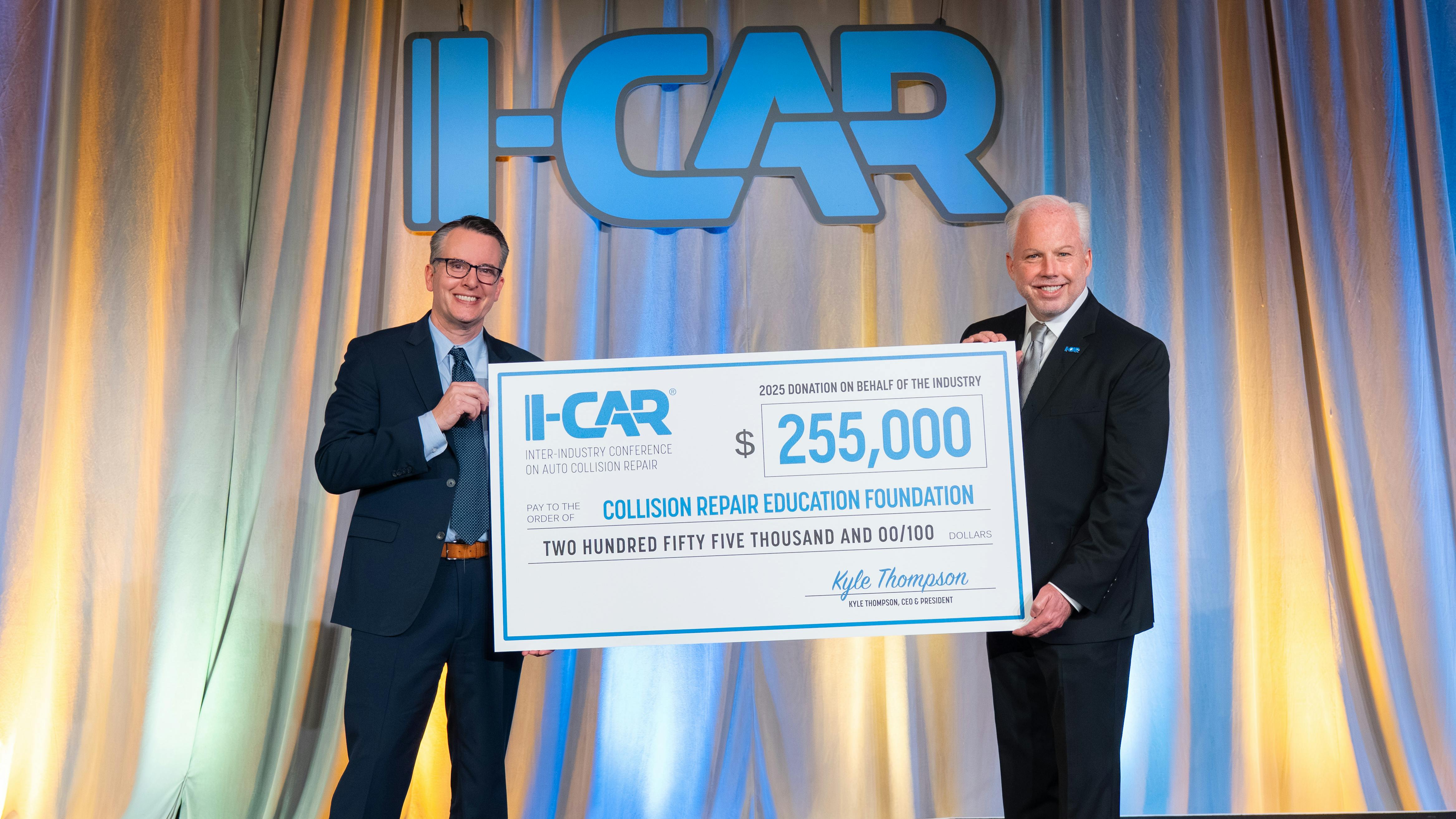 CREF Executive Director Brandon Eckenrode, left, accepts a donation from I-CAR President and CEO Kyle Thompson.